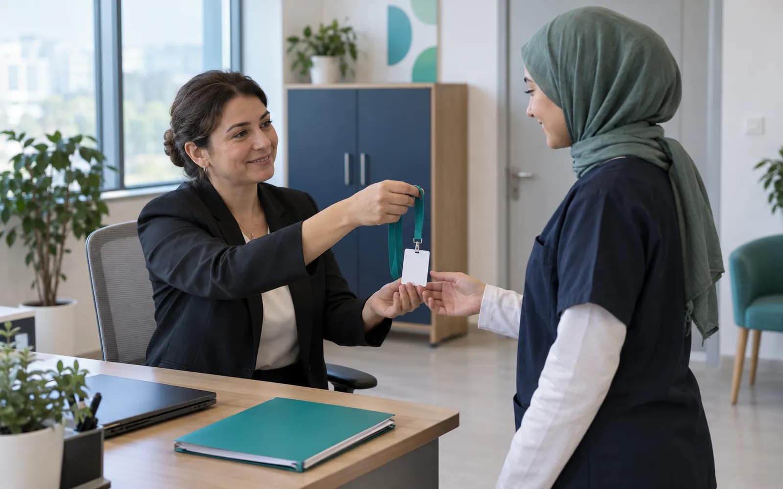 Yönetici, yeni bir çalışana boş bir kimlik kartını teslim ediyor; ofis ortamında işe giriş anı.